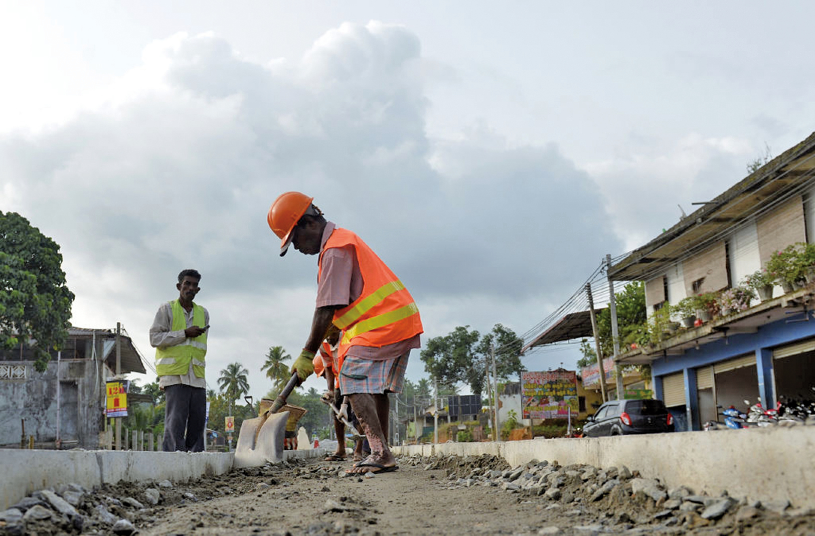 斯里蘭卡因中共的一帶一路計劃背負鉅額債務，被迫簽署一份長達99年的租約，將具有戰略意義的漢班托塔（Hambantota）港移交給中共。圖為斯里蘭卡工人在修路。（AFP）