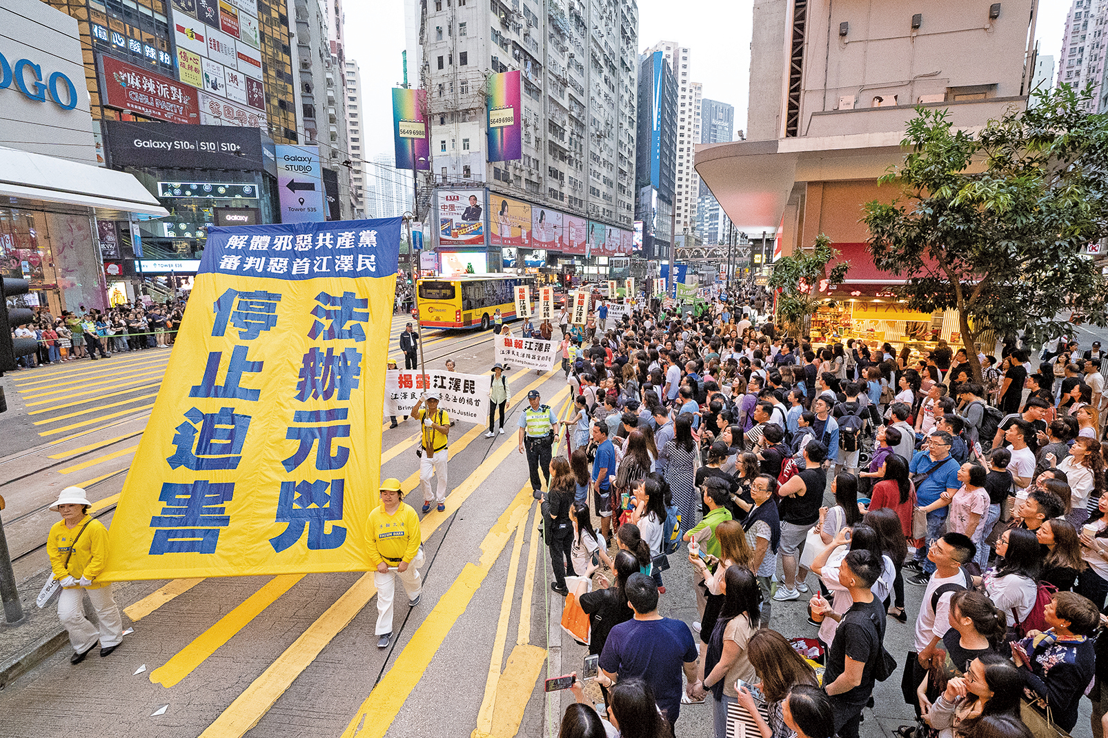 2019年4月27日，香港法輪功學員舉行紀念「四．二五」20周年暨聲援3億3千萬人退出中共集會和大遊行。壯觀的遊行隊伍途經香港銅鑼灣鬧市，大批市民和遊客夾道觀看。（李逸／大紀元）