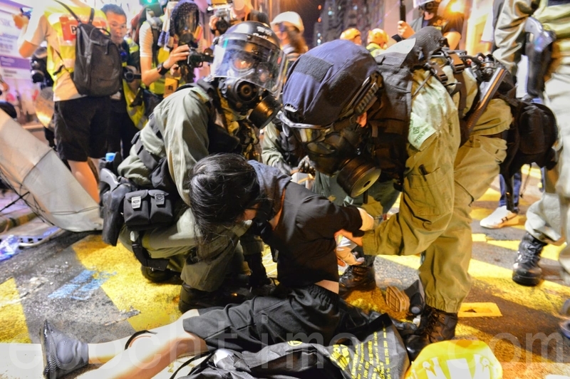 警方速龍小隊也在8時突然衝前，警方並施放催淚彈，十多位示威者被制服在地，雙手被索帶索緊。（宋碧龍／大紀元）