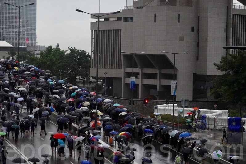 中共駐軍總部外，有市民站在天橋喊「後果自負」口號，回應中共軍隊對香港的恐嚇之詞。（余鋼／大紀元）