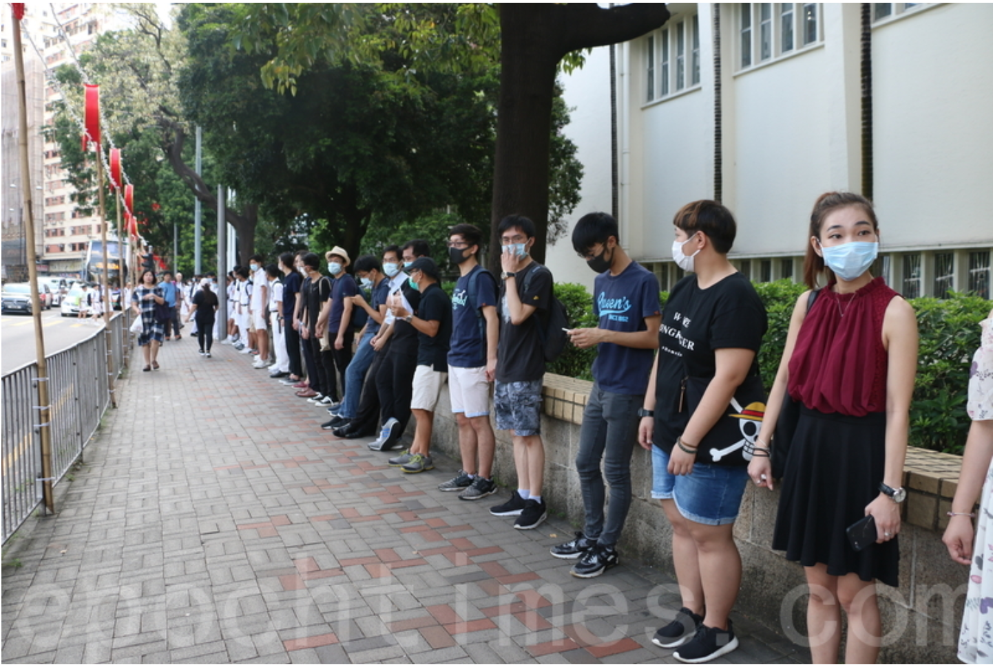 在皇仁書院校門外，超過兩百名的學生及舊生手拖手組成人鏈，呼籲「五大訴求，缺一不可」。（葉依帆 / 大紀元）