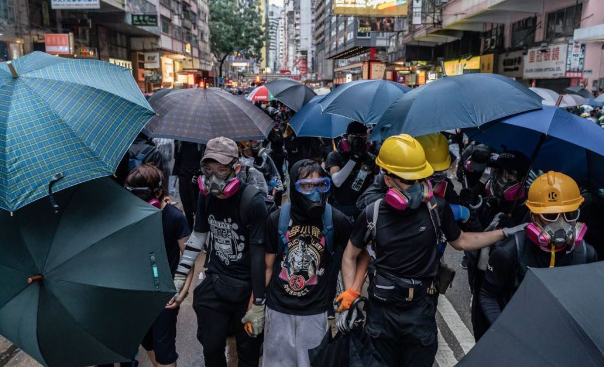 中國香港抗議者於10月6日在金鐘區舉行了「反極權反緊急法大遊行」，面對前來進行鎮壓的警方，佩戴了防護面罩的抗議者紛紛撐起雨傘準備抵禦警方發射的催淚彈。（Anthony Kwan/Getty Images）