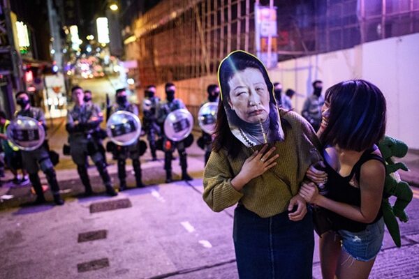 有民眾戴著香港律政司司長鄭若驊頭像面具抗議。（ANTHONY WALLACE/AFP via Getty Images）