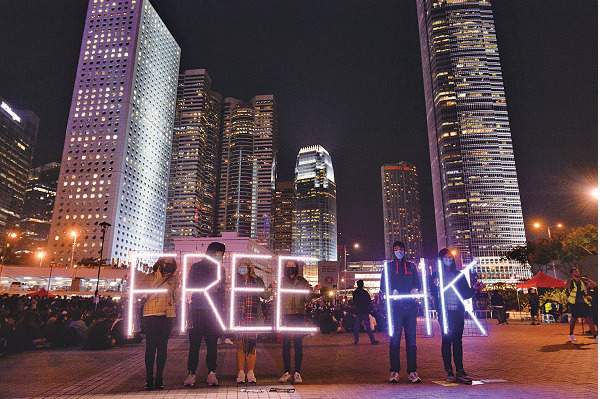 有集會人士在會場外圍舉起「FREE HK」（解放香港）螢光牌。（宋碧龍／大紀元）