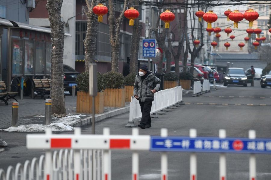 圖為2020年2月9日，一名男子戴著口罩走在北京某住宅小區的路上。（GREG BAKER/AFP via Getty Images）