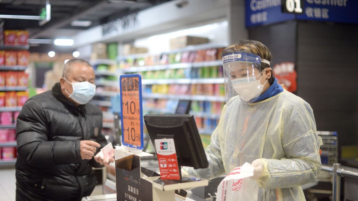 圖為武漢超市裏戴著口罩的工作人員和市民。（STR/AFP via Getty Images）