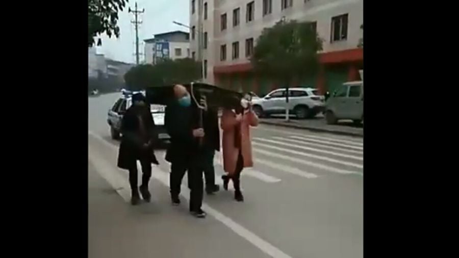 重慶抓捕四個打麻將的人，命令四人抬麻將桌遊街。（影片截圖）