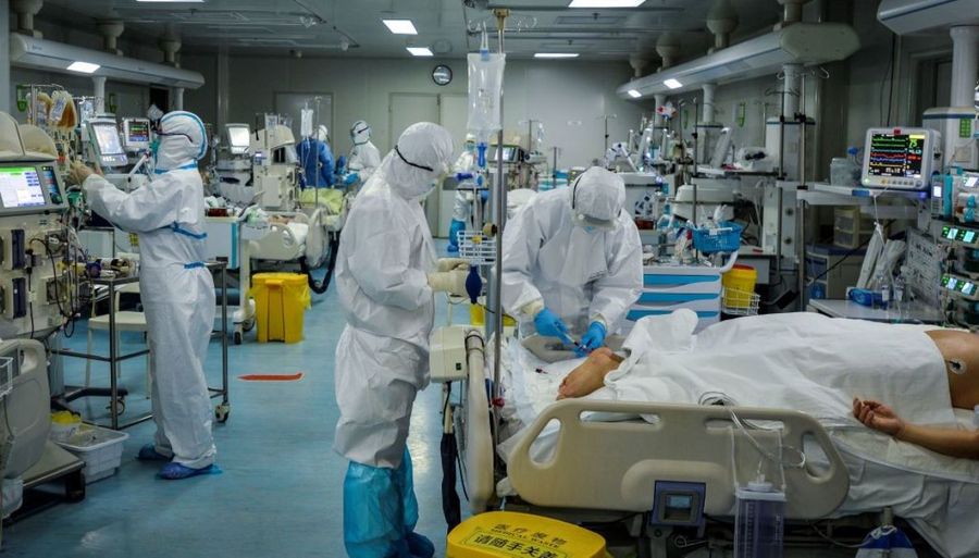 中國湖北省武漢市一家醫院的醫務人員2020年2月24日正在對一名中共病毒（CCP Virus，俗稱COVID-19病毒）感染的患者進行治療。（STR/AFP via Getty Images）