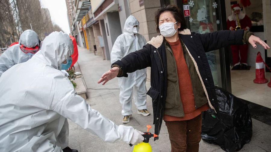 一名武漢婦女正在接受志願者的消毒。（STR/AFP via Getty Images）