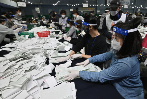 中共肺炎疫情全球大流行之際，南韓國會如期舉行21屆國會選舉，經過一整晚開票，執政黨共同民主黨與因應這次席次計算新制而成立的共同市民黨共拿下180席。（JUNG YEON-JE/AFP via Getty Images）