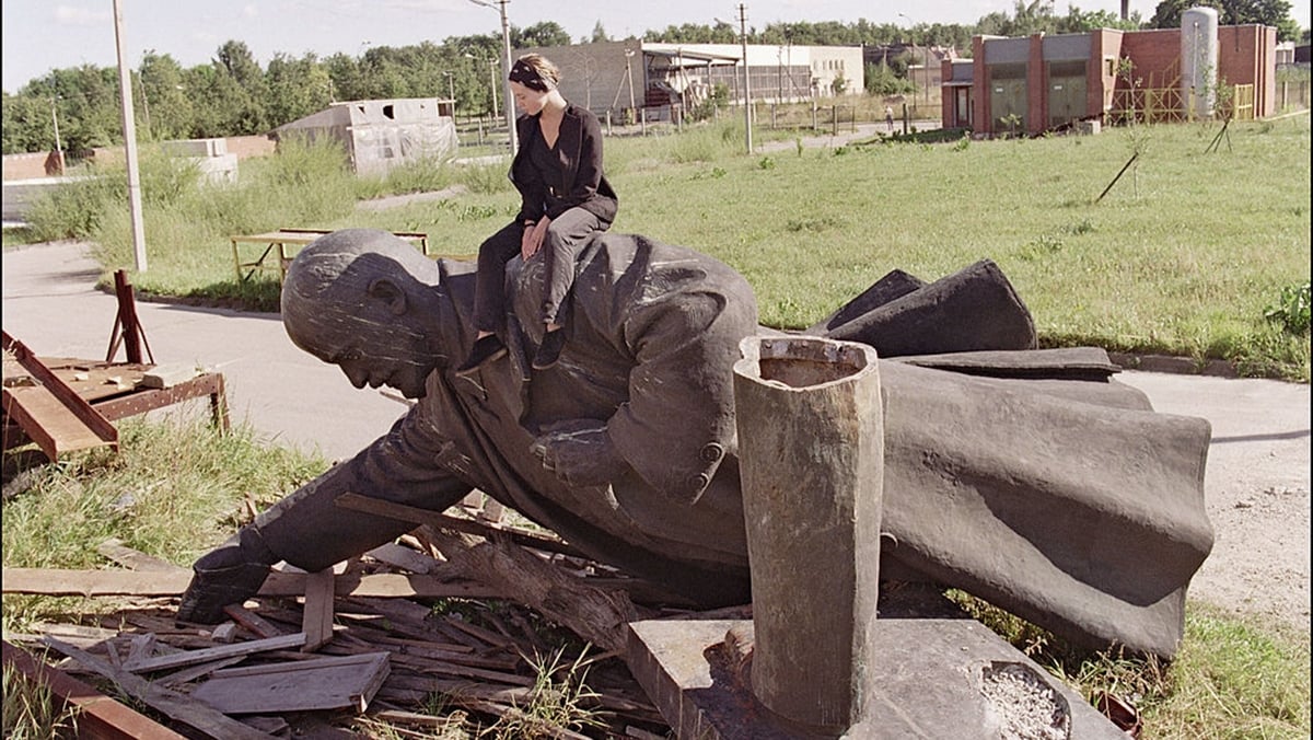 波蘭作家維克多・沙博爾夫斯基（Witold Szablowski）近日表示，中共隱瞞疫情可能是其崩盤的警訊。圖為1991年9月1日，一個年輕的立陶宛女孩坐在被拆除的列寧塑像上。（GERARD FOUET/AFP/GettyImages）