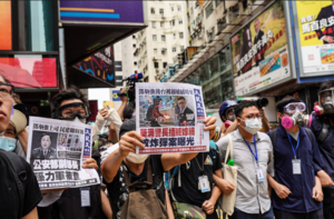 【組圖】【5.24銅鑼灣遊行】 有市民向警察展示《大紀元時報》頭版鄧炳強  年輕人被拘捕
