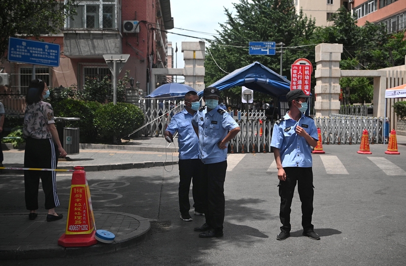 6月15日，幾名戴著口罩的保安人員在北京玉泉東市場附近被封鎖的居民區前值守。（NOEL CELIS／AFP via Getty Images）