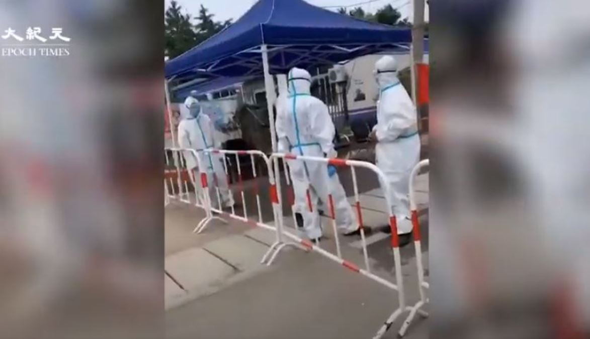 北京大興區疫情爆發點已被封鎖，由穿防護服的人員看守。（影片截圖）