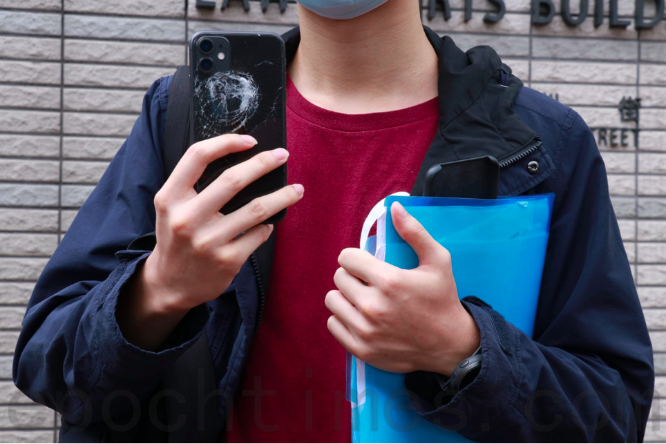 理大學生記者去年11月11日「黎明行動」期間在旺角以手機拍攝警方驅散人群，拍攝中的手機背面被防暴警員以胡椒球彈射中，明顯凹陷。（杜夫／大紀元）