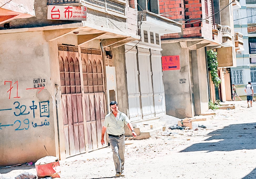 在海外的中國勞工，其工作、生活條件都很差，醫療條件也不行。圖為阿爾及利亞的一處破敗的街道上，有幾家中國商店。（Getty Images)