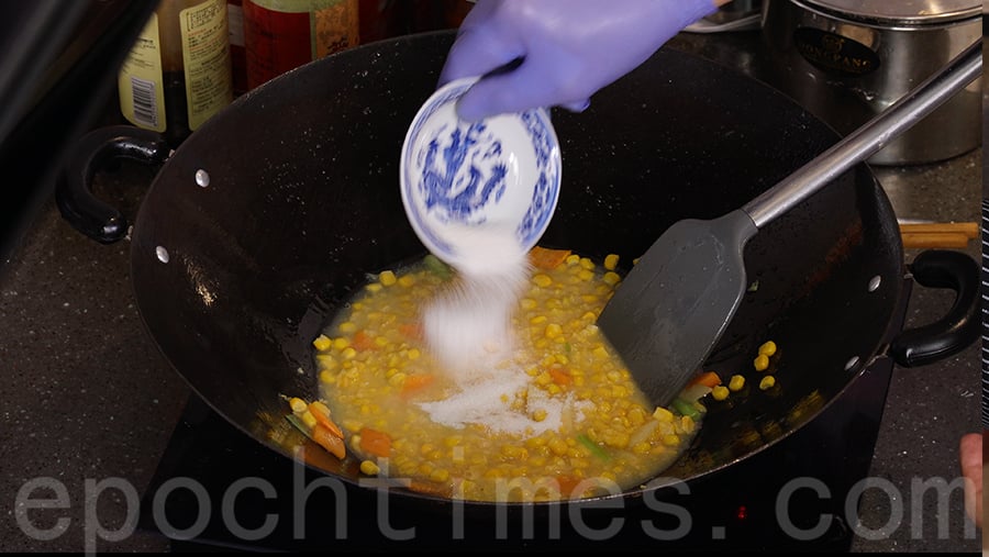 在鑊中加入半碗清水、粟米粒和粟米蓉，並加入糖、鹽和胡椒粉。（陳仲明／大紀元）