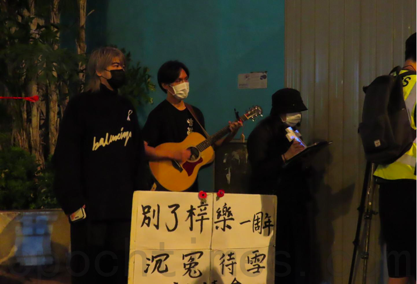 11月8日晚，有市民前往將軍澳尚德停車場附近悼念周梓樂逝世周年，歌手阮民安（左）也到場。（Pinky／大紀元）