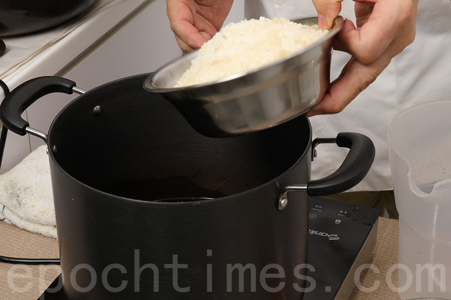在鍋中加入冰糖，攪拌均勻煮糖漿。（陳仲明／大紀元）