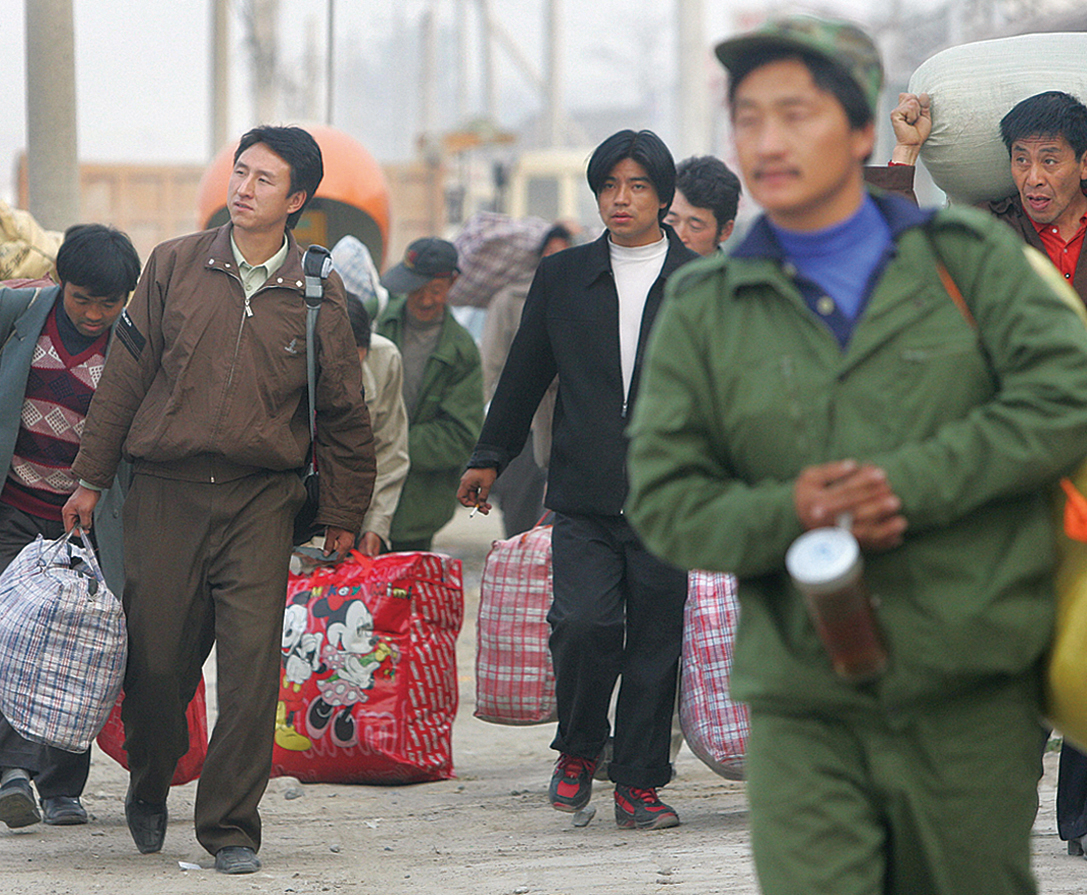 圖為2005年10月26日中國的農民工在趕路。（FREDERIC J.BROWN/AFP via Getty Images）