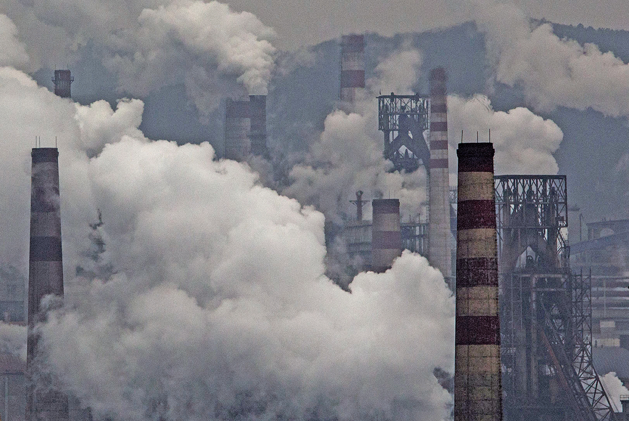 2015年11月19日，在中國工業大省河北，一家鋼鐵廠的煙囪和一台燃煤發電機冒出大量濃煙。（Getty Images）