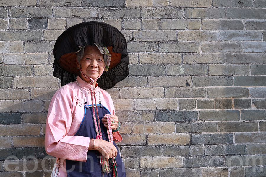 鄧梁少霞（麟娘）穿上傳統服飾，戴上涼帽，彷彿回到了過去的時光。（陳仲明／大紀元）
