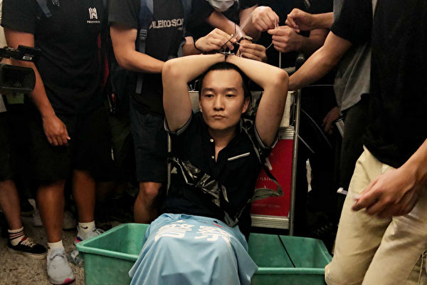 2019年8月13日，「反送中」抗爭者在香港機場發起「和你飛」集會。自稱中共黨媒《環球時報》記者的付國豪挑釁民眾，遭到抗爭者毆打。(Anthony Kwan/Getty Images)