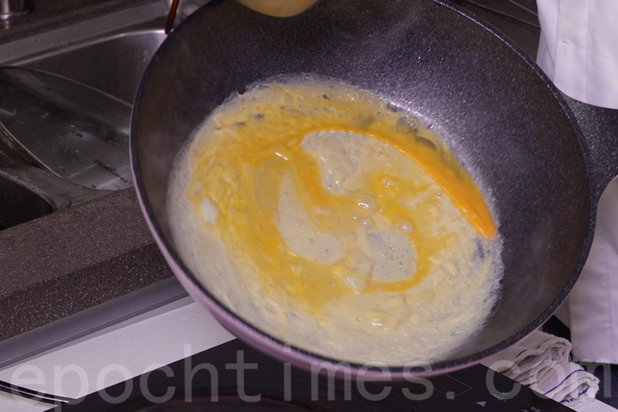 將雞蛋攪拌均勻，倒入鍋中煎蛋皮。（陳仲明／大紀元）