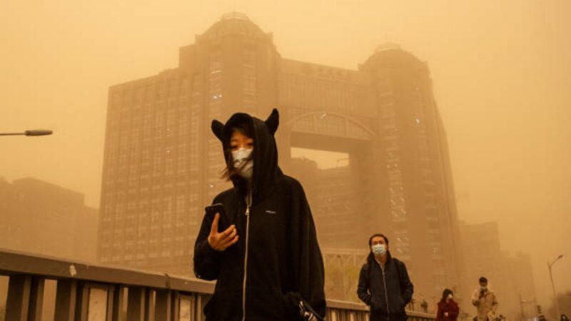 3月15日，北京市民在沙塵暴中行走。（Kevin Frayer／Getty Images）