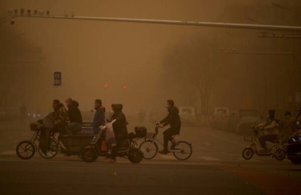 3月15日，北京市民在沙塵暴中行走。（Kevin Frayer／Getty Images）