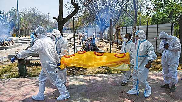 第二輪中共病毒疫情給印度帶來災難。圖為印度醫護人員正在運送死亡者屍體。（Getty Images）