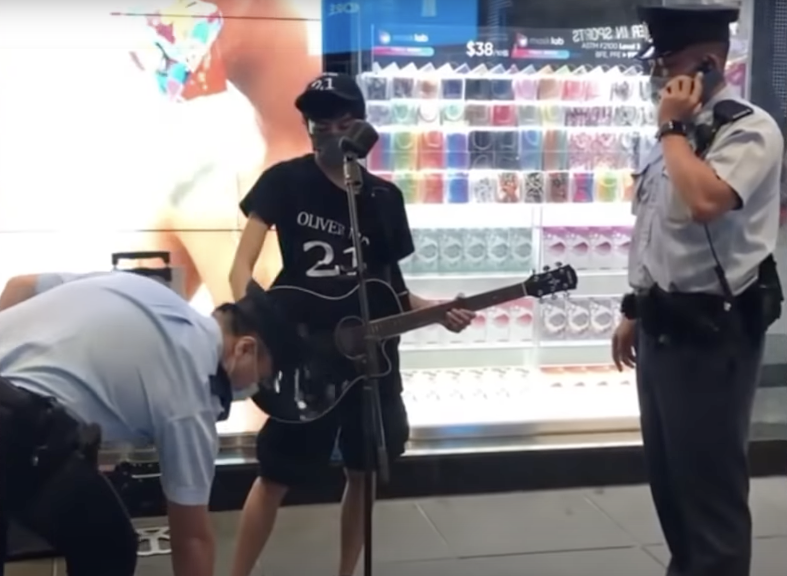 5月21日，街頭歌手Oliver Ma宣佈復出後首次在中環演唱，隨即被警方以「在公眾地方作出擾亂秩序的行為」拘捕，他的結他、音箱、咪架也被沒收。（大紀元影片截圖）