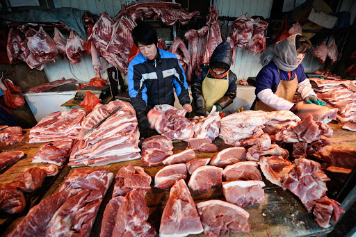 2021年2月中國新年過後，中國的生豬價格一路下跌，部份地區甚至跌破每斤10元人民幣。養豬利潤驟降令養殖戶損失巨大；此外，中共還對豬場進行強拆，養殖戶被逼入絕境。圖為北京一家市場裡的豬肉攤位。（TEH ENG KOON／AFP via Getty Images）