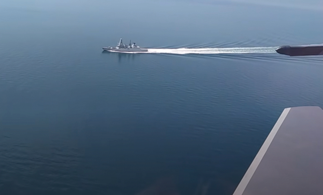 俄羅斯國防部公佈的影片中，一架蘇-30SM戰鬥機從英國軍艦一旁飛過。（影片截圖）