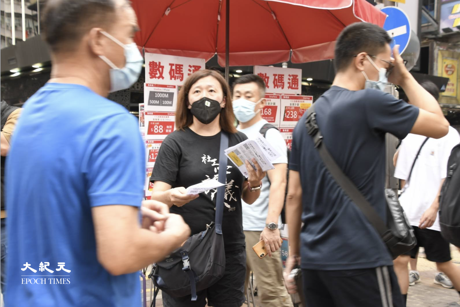 7月1日，香港警方在多地嚴密佈防，社工陳虹秀剛要擺街站，卻被警察阻止，她表示，不給擺街站，就派單張。（麥碧/大紀元）
