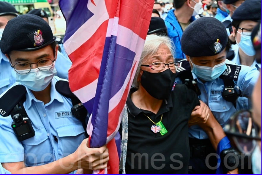7月1日午後2時40分許，王婆婆手持英國旗幟出現在達百德新街及記利佐治街交界處，之後被數十警員包圍後被帶走。（宋碧龍／大紀元）