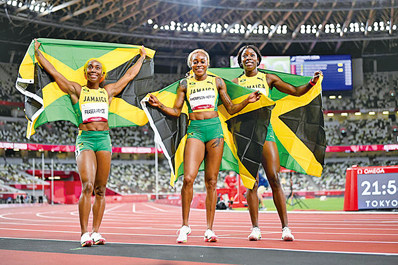 東京奧運田徑賽場，三位牙買加「飛人」包攬了女子100米跑前三名，其中衛冕成功的湯普森（中）打破了已塵封33年的奧運會紀錄。（Matthias Hangst/Getty Images）
