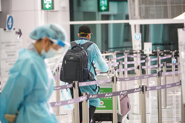 本港新增4宗中共病毒（武漢肺炎）輸入個案。圖為香港國際機場有旅客穿著保護服。（余鋼／大紀元）