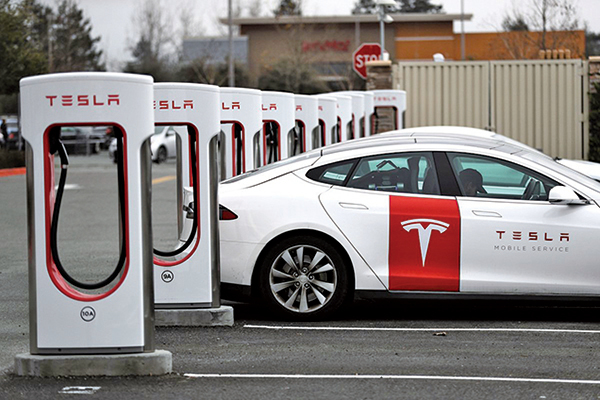 圖為一輛Tesla電車正在加州一充電站充電。（Justin Sullivan/Getty Images）