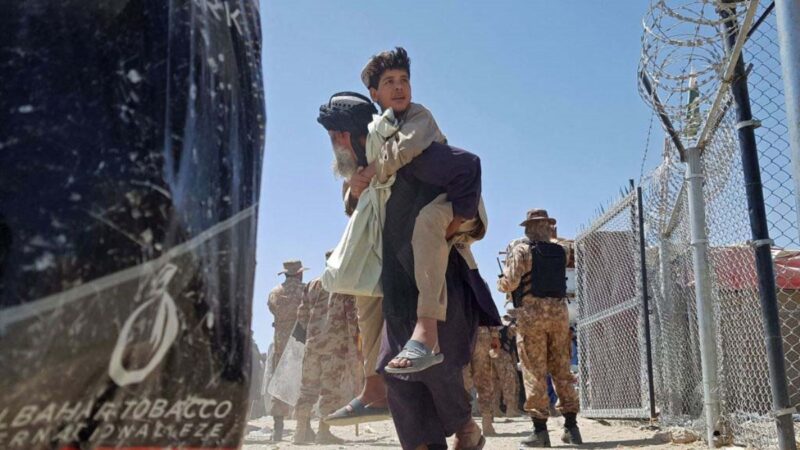 塔利班逼近阿富汗首都喀布爾50公里；北約召開緊急會議，重點商討撤出阿富汗的計劃。圖為2021 年 8 月 13 日，塔利班武裝組織控制了阿富汗邊境城鎮後，一位阿富汗平民背著他的兒子走過了阿富汗與巴基斯坦交界的邊境線。（AFP via Getty Images）