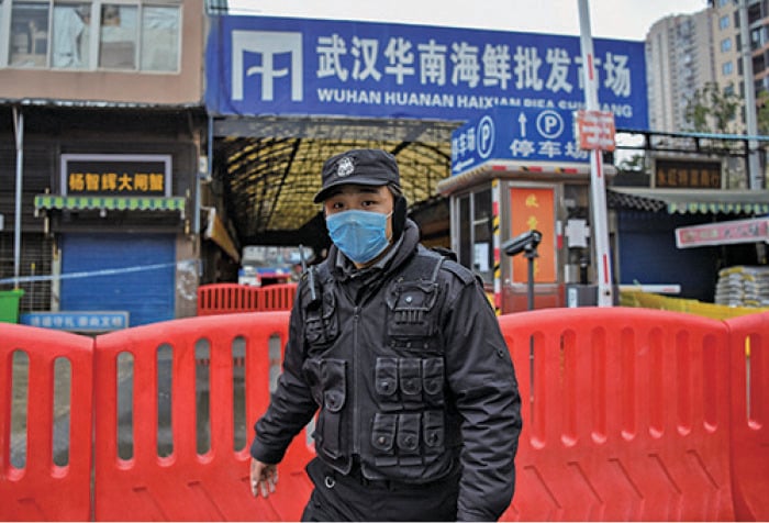 圖為1月25日一名公安站在武漢華南海鮮市場外。(AFP)