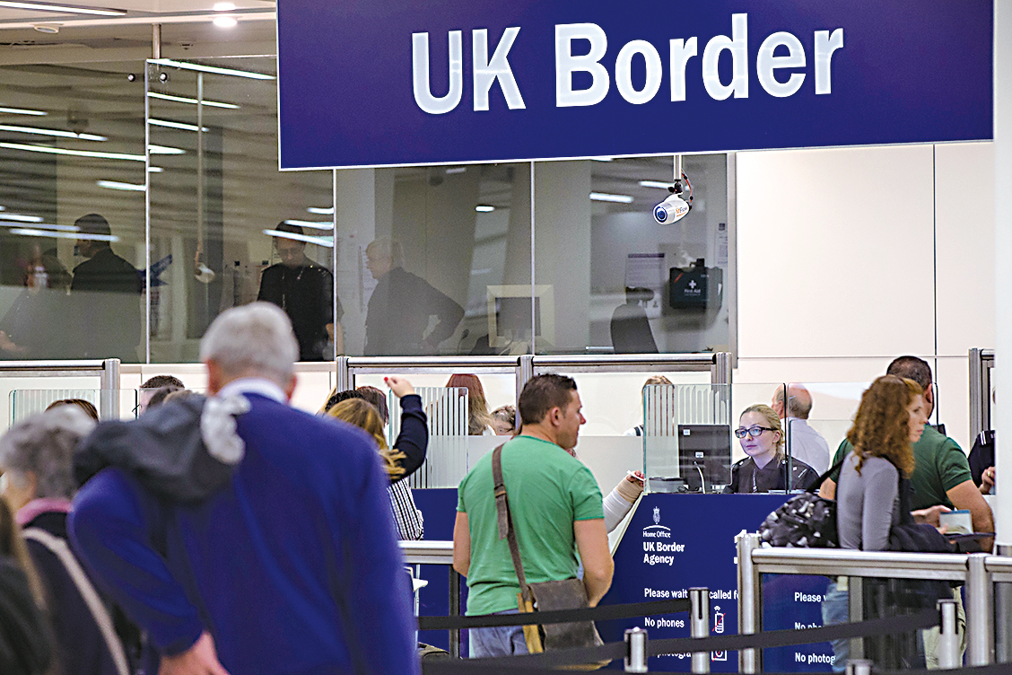 英國邊境檢查署（UK Border force）在倫敦格域機場（Gatwick Airport）檢查抵達機場的乘客的護照。（Oli Scarff/Getty Images）