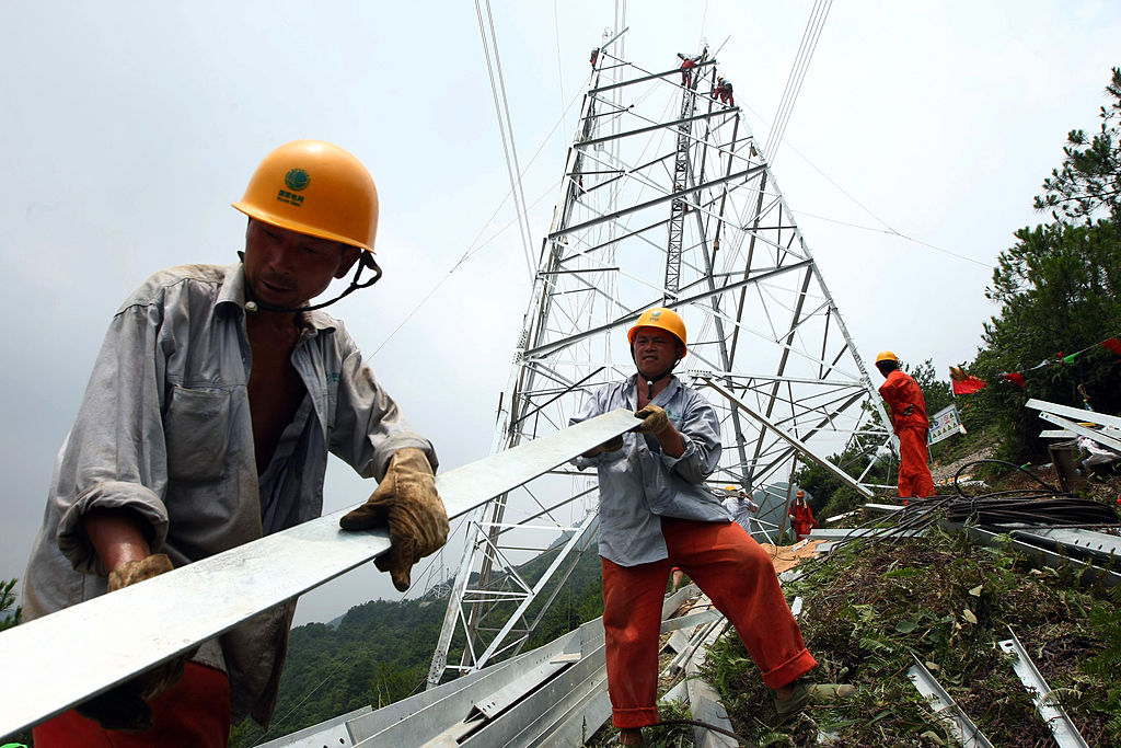近期，限電、停產正在席捲中國至少十餘個省份，使大批企業和相關產業鏈受到波及。圖為浙江省永嘉縣，工人們在建造一座輸電塔。（China Photos/Getty Images）