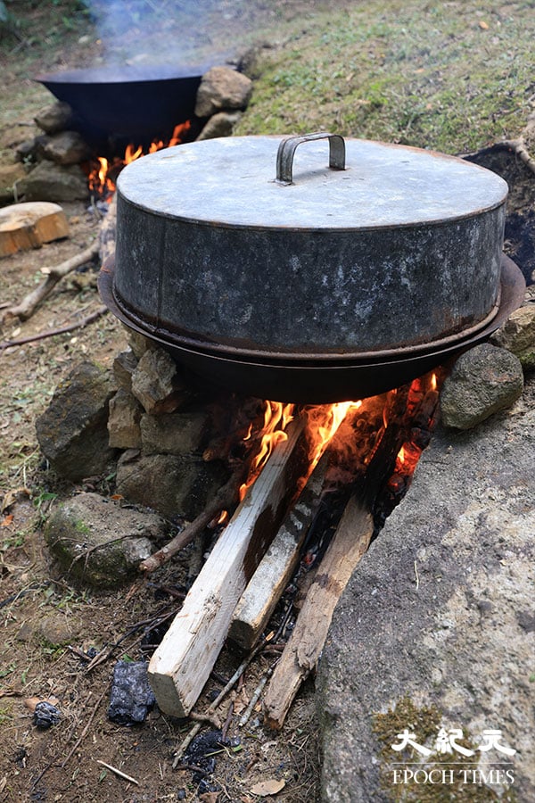 2021年蓮花山秋祭，聯哥改以即場挖掘的兩個土坑來生火煮食，並沒有使用現場的爐灶。（陳仲明／大紀元）
