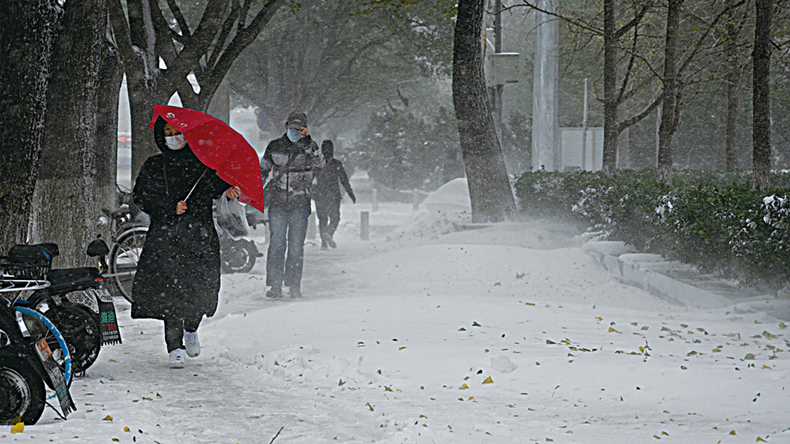 11月7日，北京降暴雪，市民在暴風雪中行走。（NOEL CELIS/AFP via Getty Images）