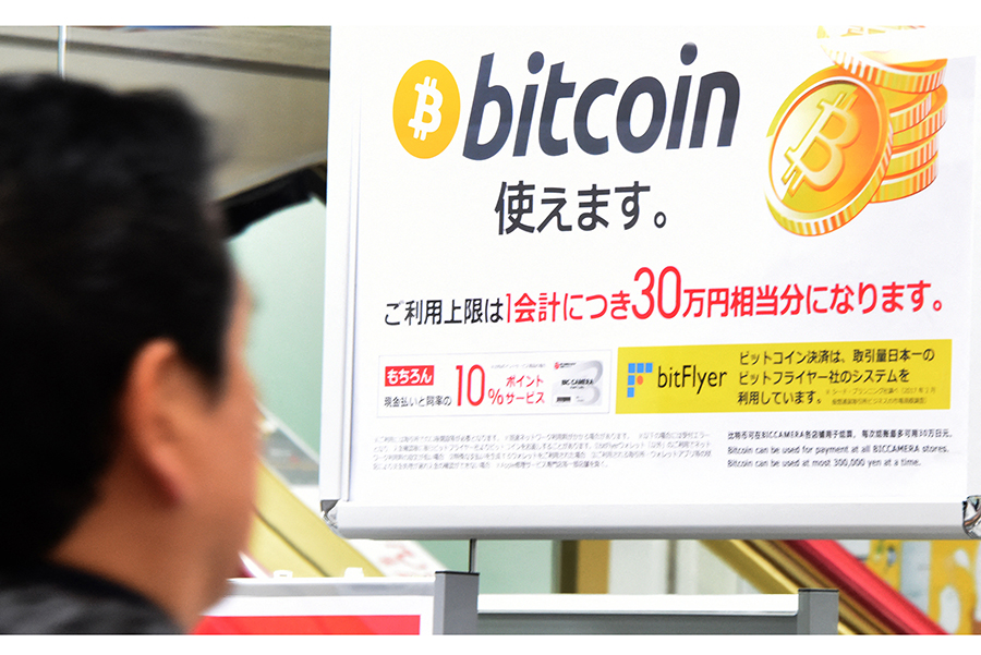 東京稅務局發現中國資金通過比特幣等加密貨幣流入日本。圖為東京一商店可使用比特幣交易的廣告。（Toru Yamanaka/AFP）