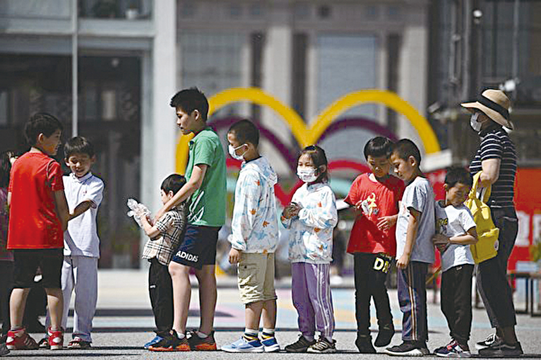 5月31日，北京政府宣布將允許一對夫婦生育3個孩子。圖為6月1日北京兒童排隊玩滑梯的情景。（NOEL CELIS/AFP via Getty Images）
