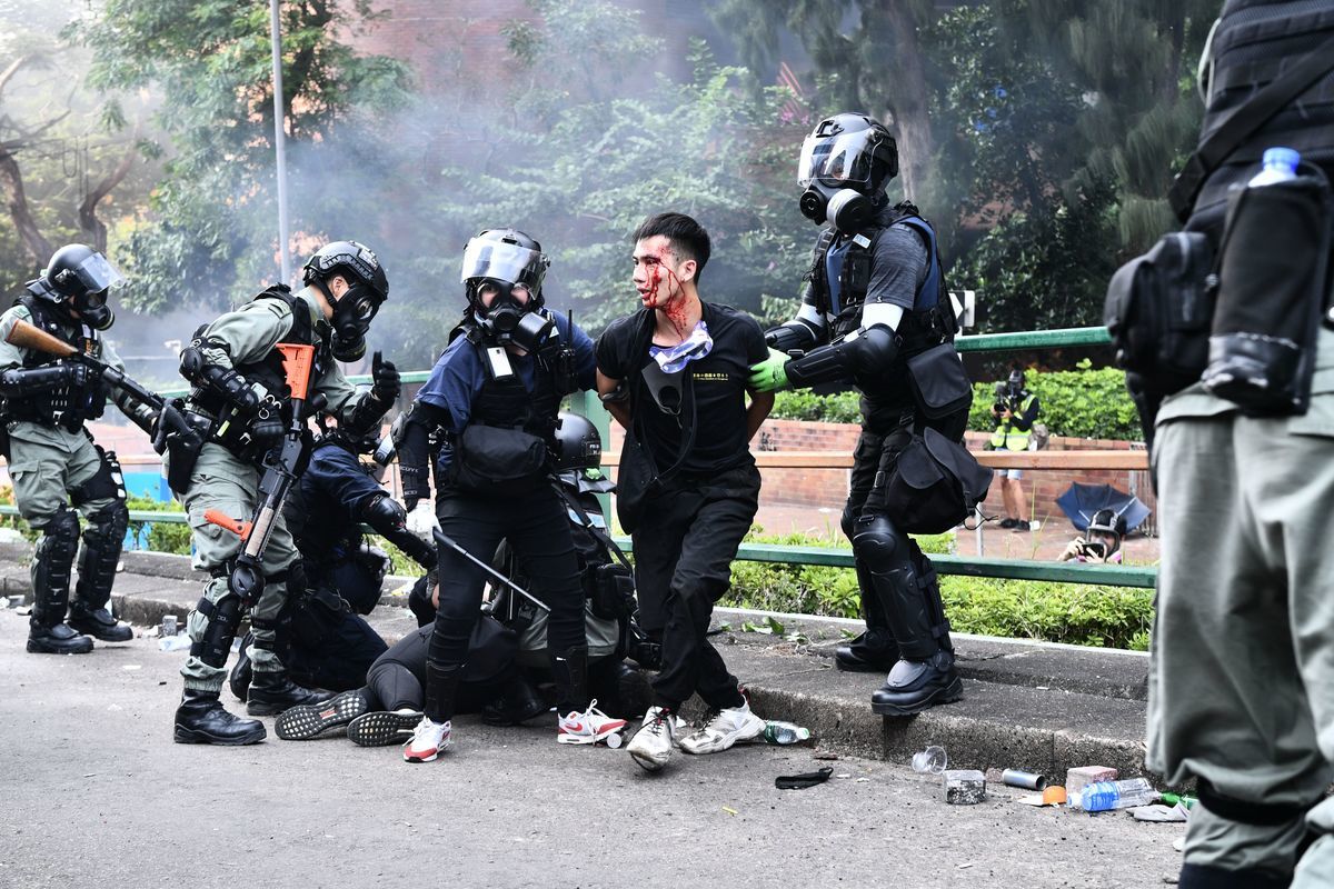 2019年11月18日，香港防暴警察逮捕理大學校園內一名臉部受傷的抗爭者。(ANTHONY WALLACE/AFP via Getty Images)