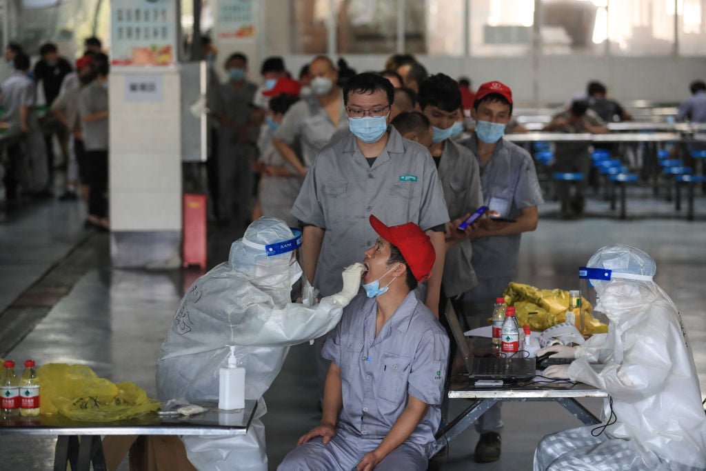 中共病毒（Covid-19）疫情蔓延之下，浙江經濟日漸蕭條，民生艱難。圖為2021年8 月4日一名工人在工廠的餐廳接受核酸檢測。（法新社）
