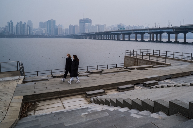 2021年12月29日，韓國首爾民眾在漢江邊散步。（ANTHONY WALLACE/AFP via Getty Images）